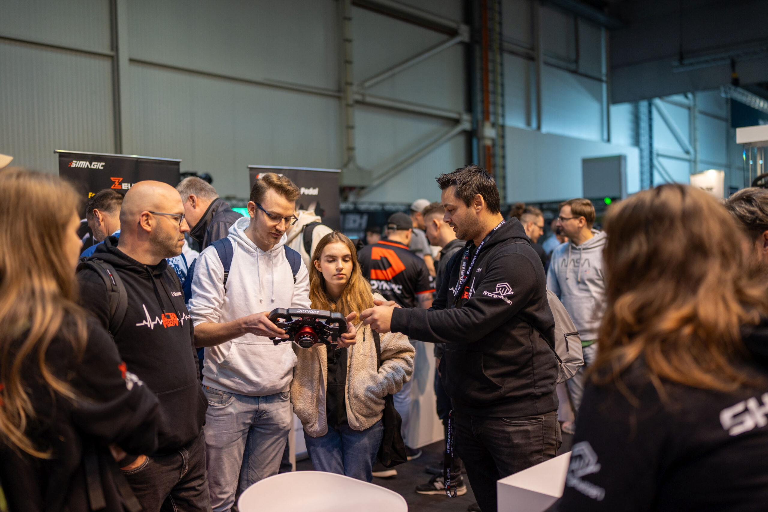 People gathered around an exhibitor at SimRacing Expo in Frankfurt.